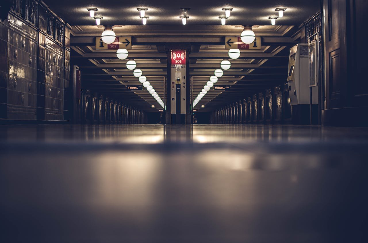Dark and moody view of an empty underground subway station with modern lighting and steel architecture.